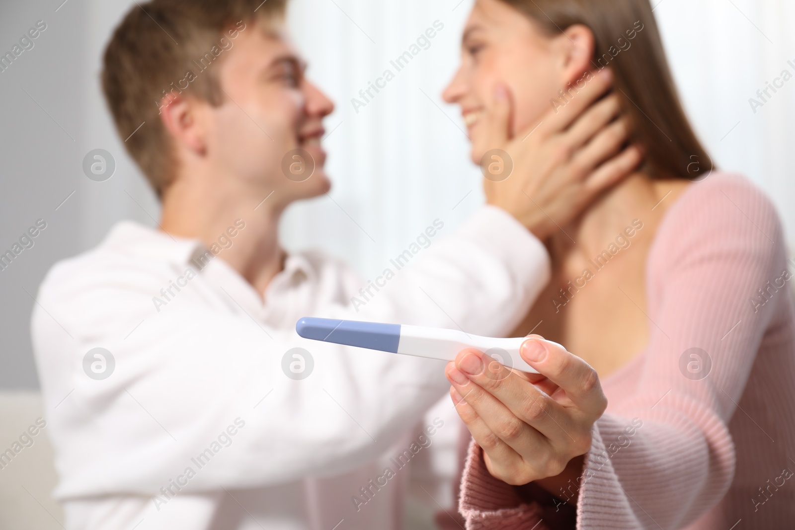 Happy couple with pregnancy test at home, selective focus Photo of Happy couple with pregnancy test at home, selective focus