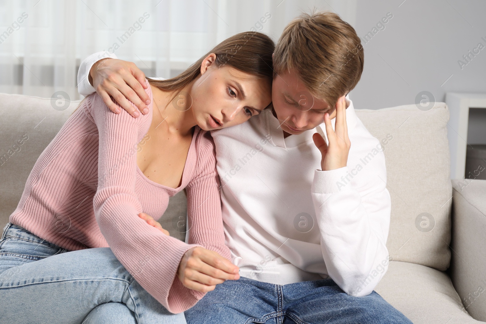 Worried couple with pregnancy test on sofa at home Photo of Worried couple with pregnancy test on sofa at home