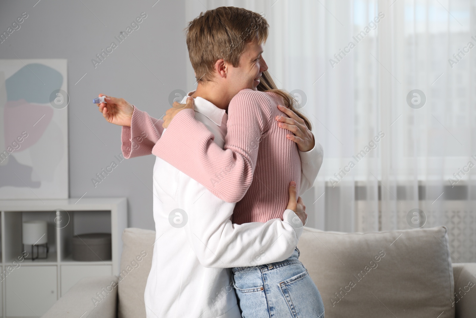 Happy couple with pregnancy test at home Photo of Happy couple with pregnancy test at home