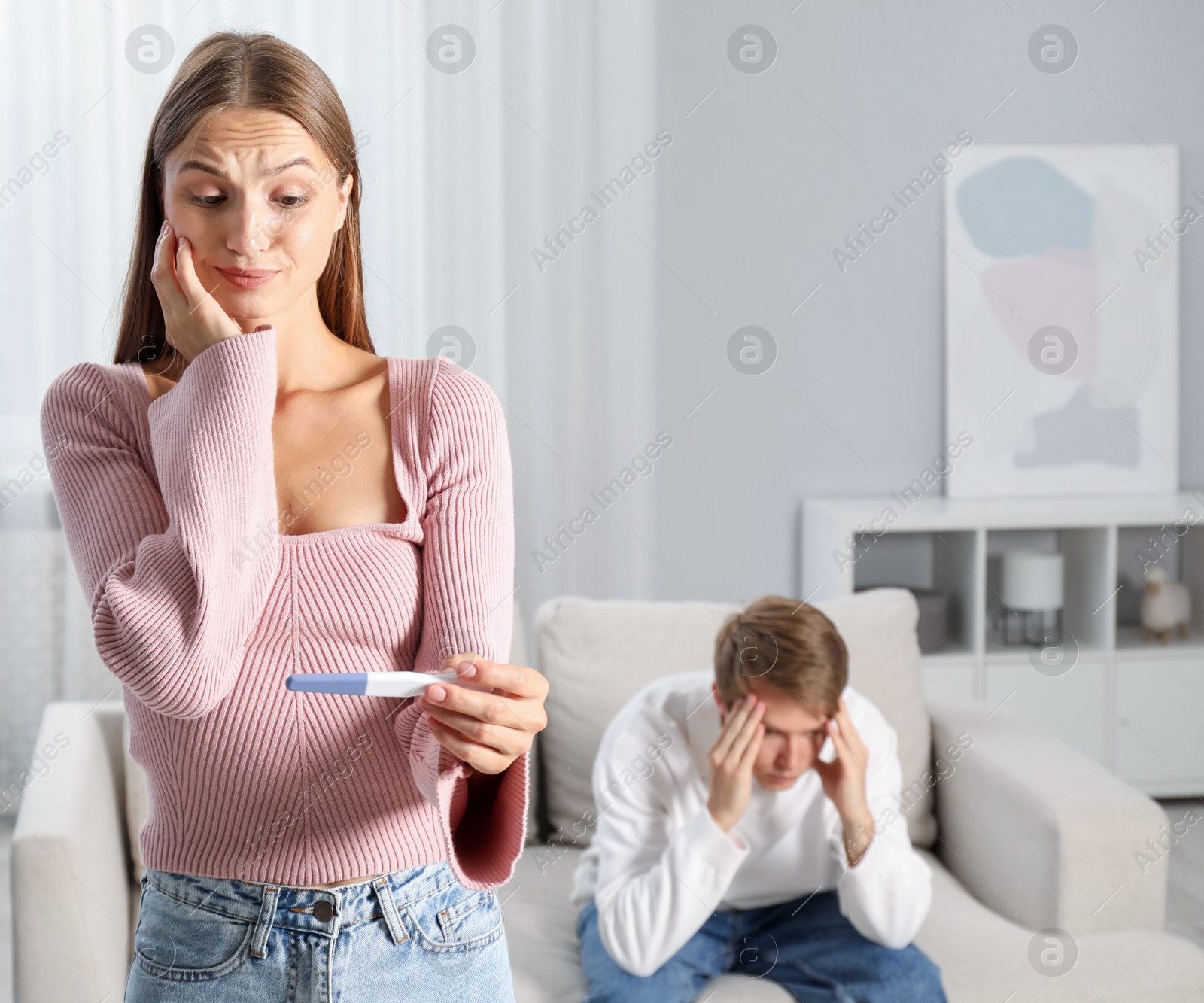 Worried woman with pregnancy test and her husband at home, selective focus Photo of Worried woman with pregnancy test and her husband at home, selective focus