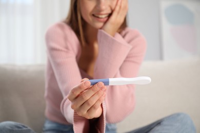 Photo of Woman with pregnancy test at home, closeup