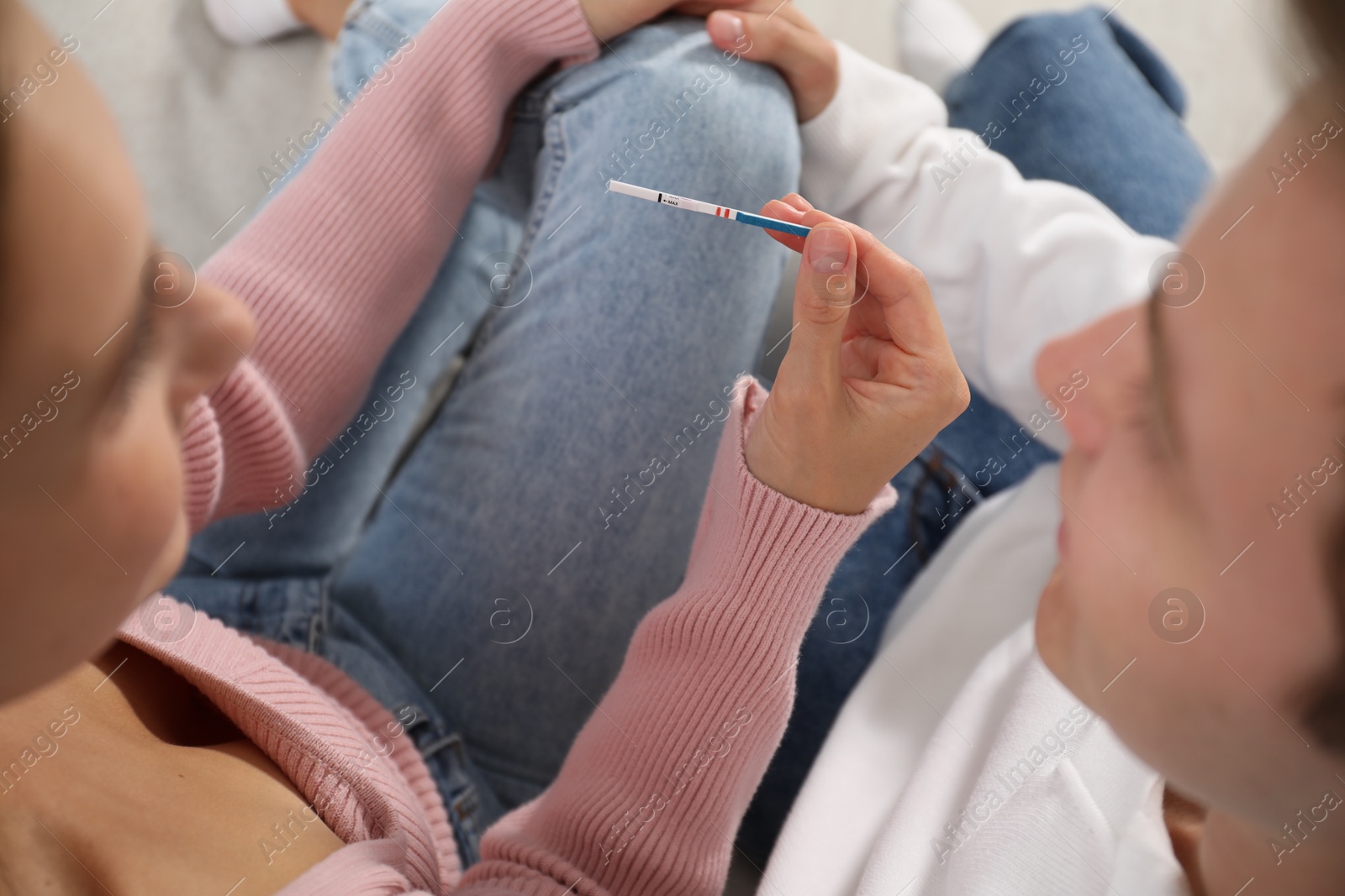 Photo of Couple with positive pregnancy test indoors, closeup