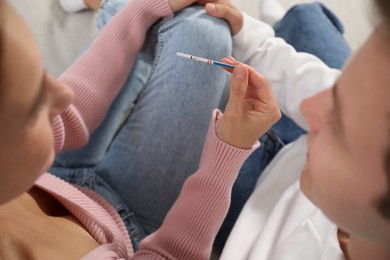 Photo of Couple with positive pregnancy test indoors, closeup