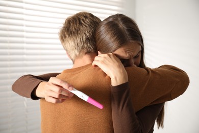 Photo of Worried couple with pregnancy test at home