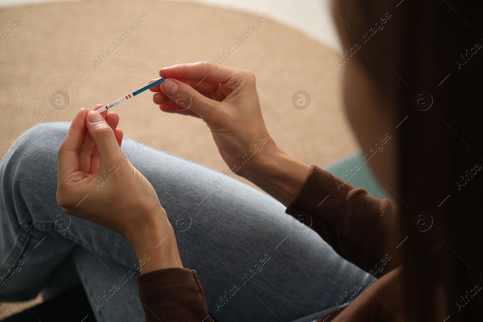 Photo of Woman with positive pregnancy test indoors, closeup