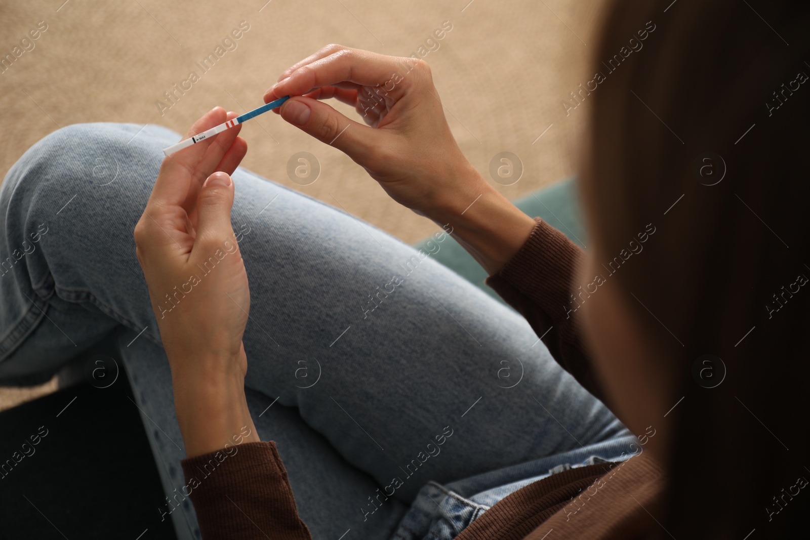Photo of Woman with positive pregnancy test indoors, closeup
