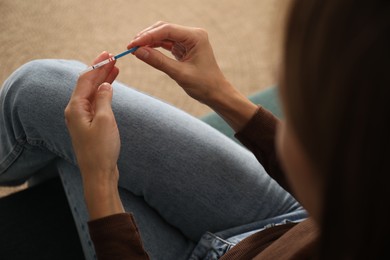 Photo of Woman with positive pregnancy test indoors, closeup