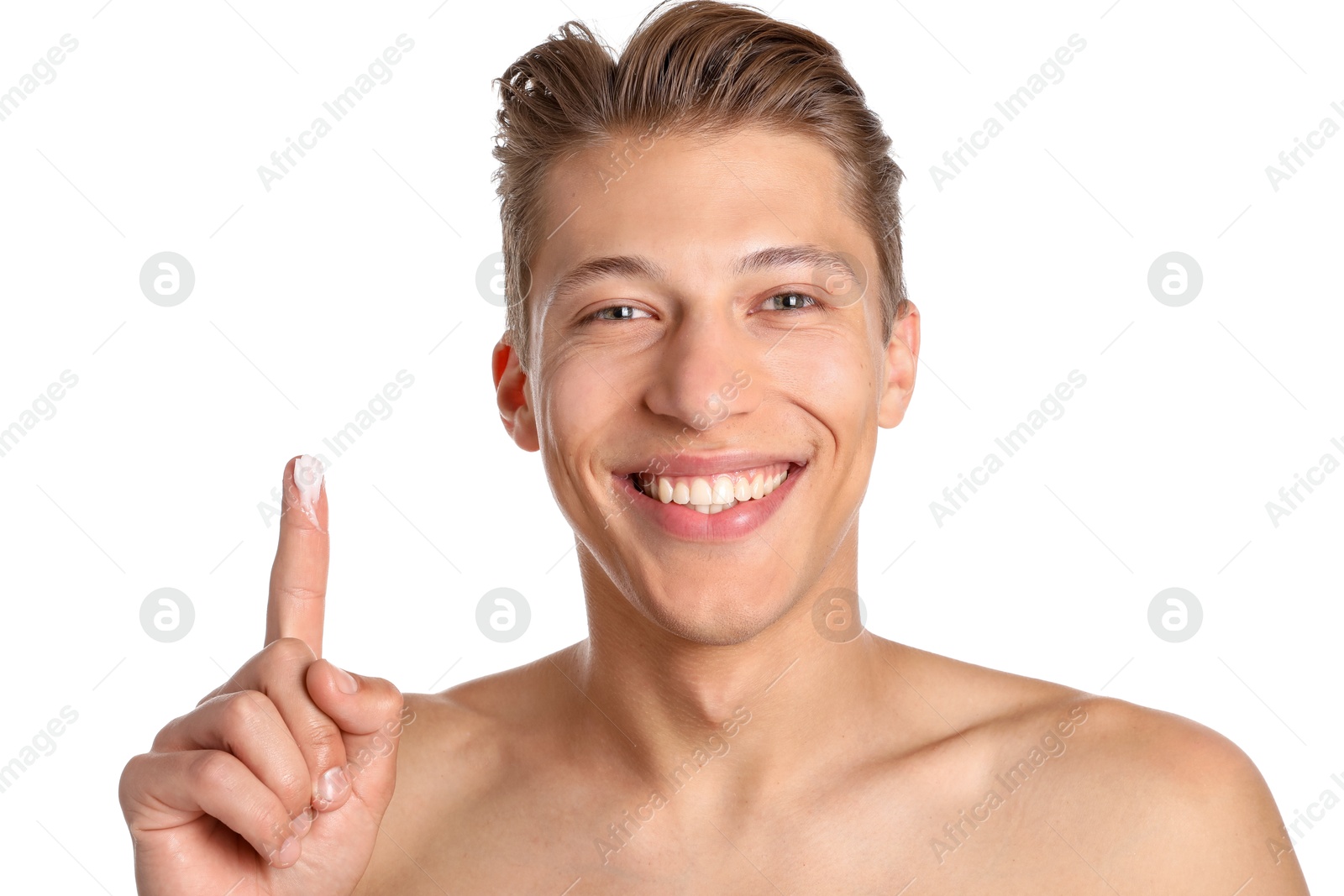 Photo of Handsome young man with face cream on finger against white background
