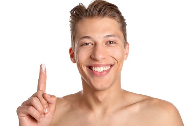 Photo of Handsome young man with face cream on finger against white background