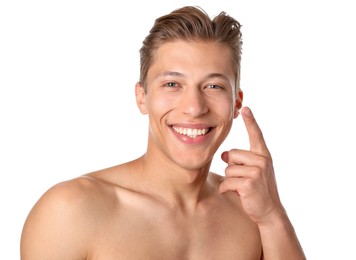 Photo of Handsome young man applying cream onto his face on white background