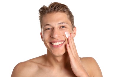 Photo of Handsome young man applying cream onto his face on white background