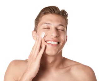 Photo of Handsome young man applying cream onto his face on white background