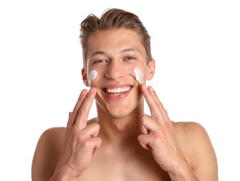 Photo of Handsome young man applying cream onto his face on white background