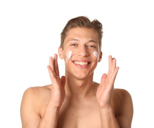Photo of Handsome young man applying cream onto his face on white background