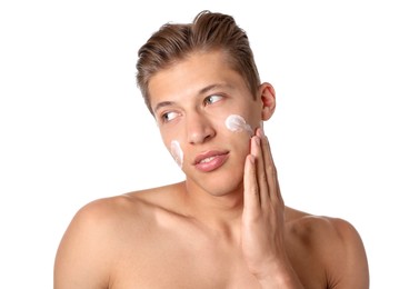 Photo of Handsome young man applying cream onto his face on white background