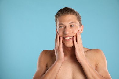 Photo of Handsome young man on light blue background, space for text
