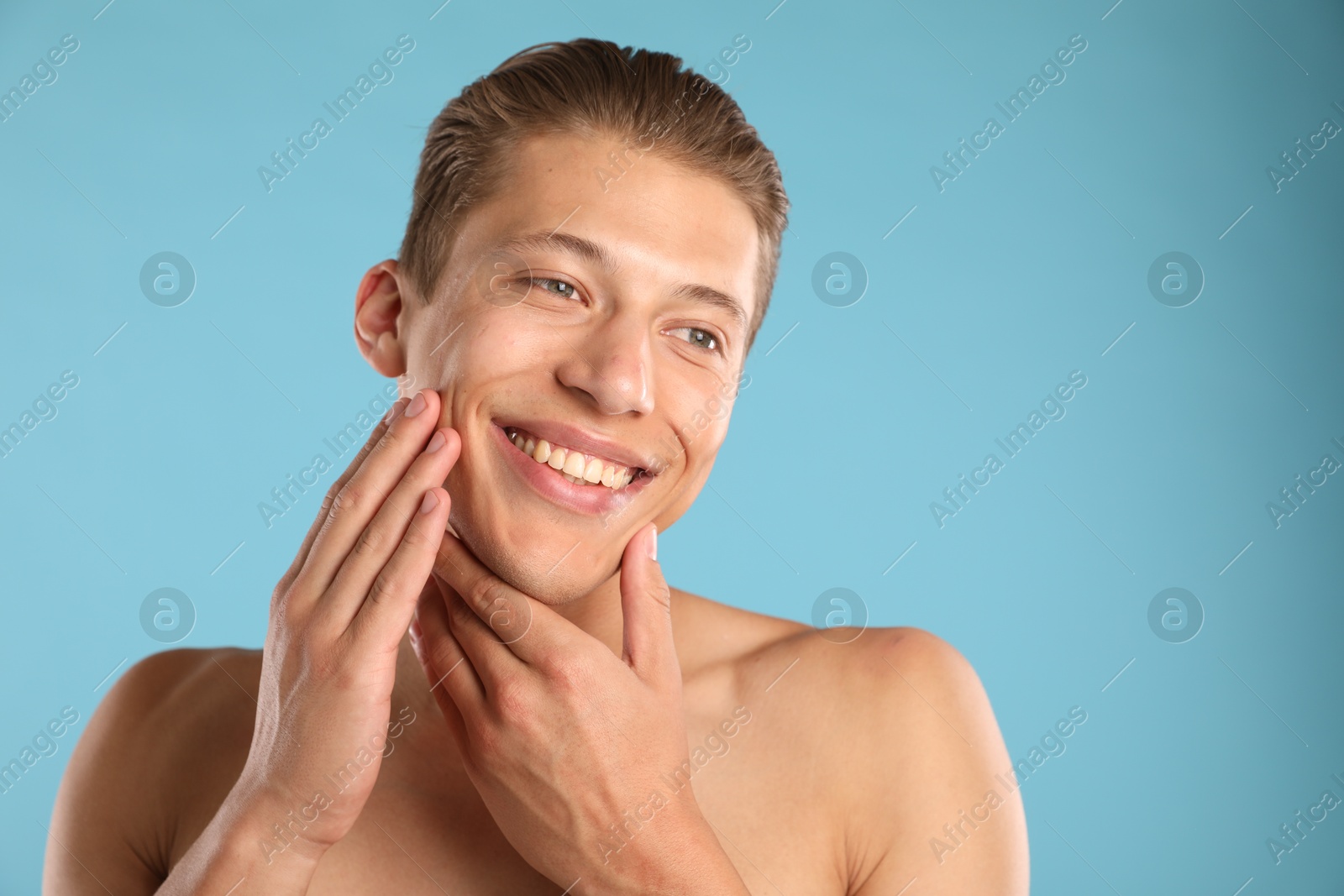 Photo of Handsome young man on light blue background, space for text