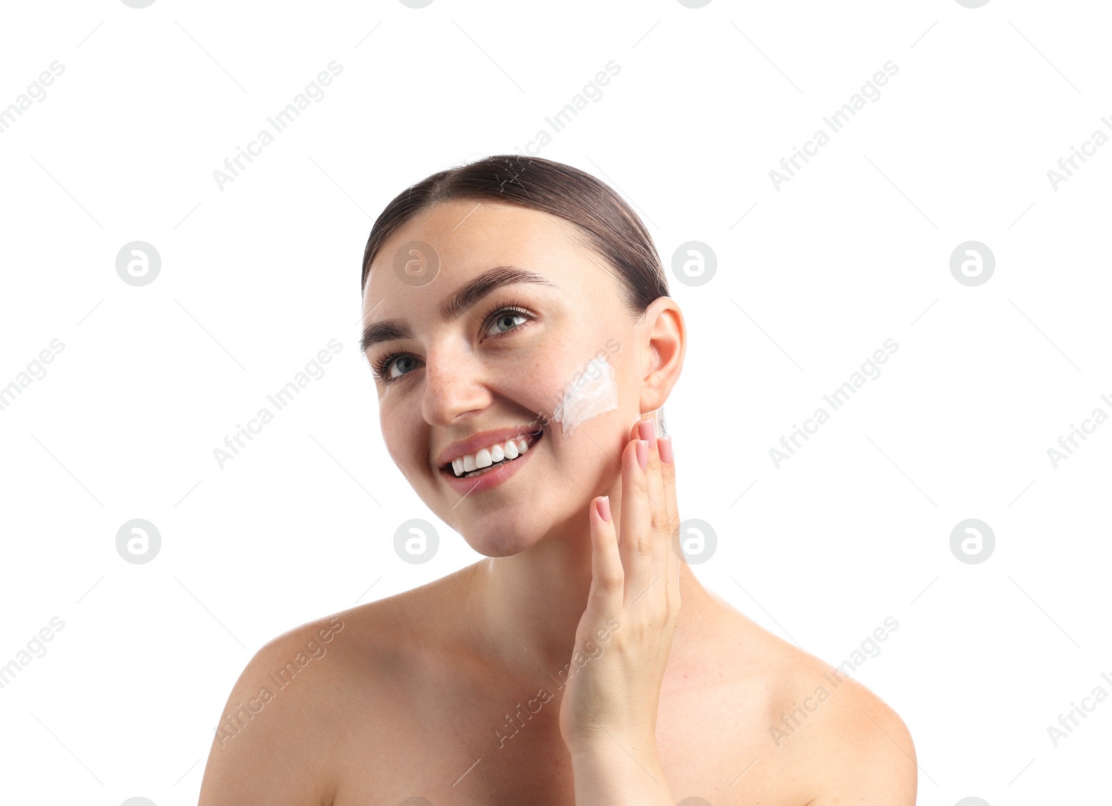 Photo of Beautiful woman applying cream onto her face on white background