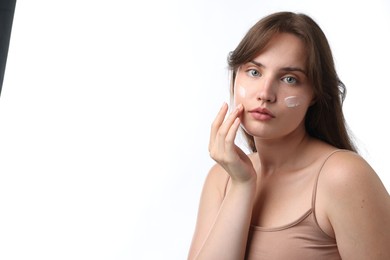 Photo of Beautiful woman with cream on her face against white background. Space for text