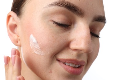 Photo of Beautiful woman with cream on her face against white background, closeup