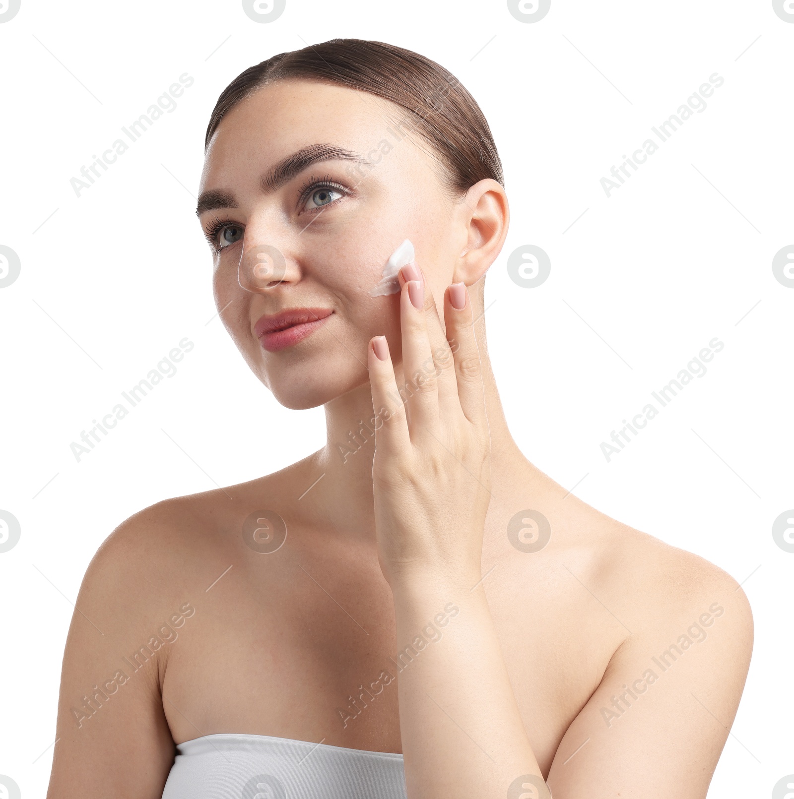 Photo of Beautiful woman applying cream onto her face on white background