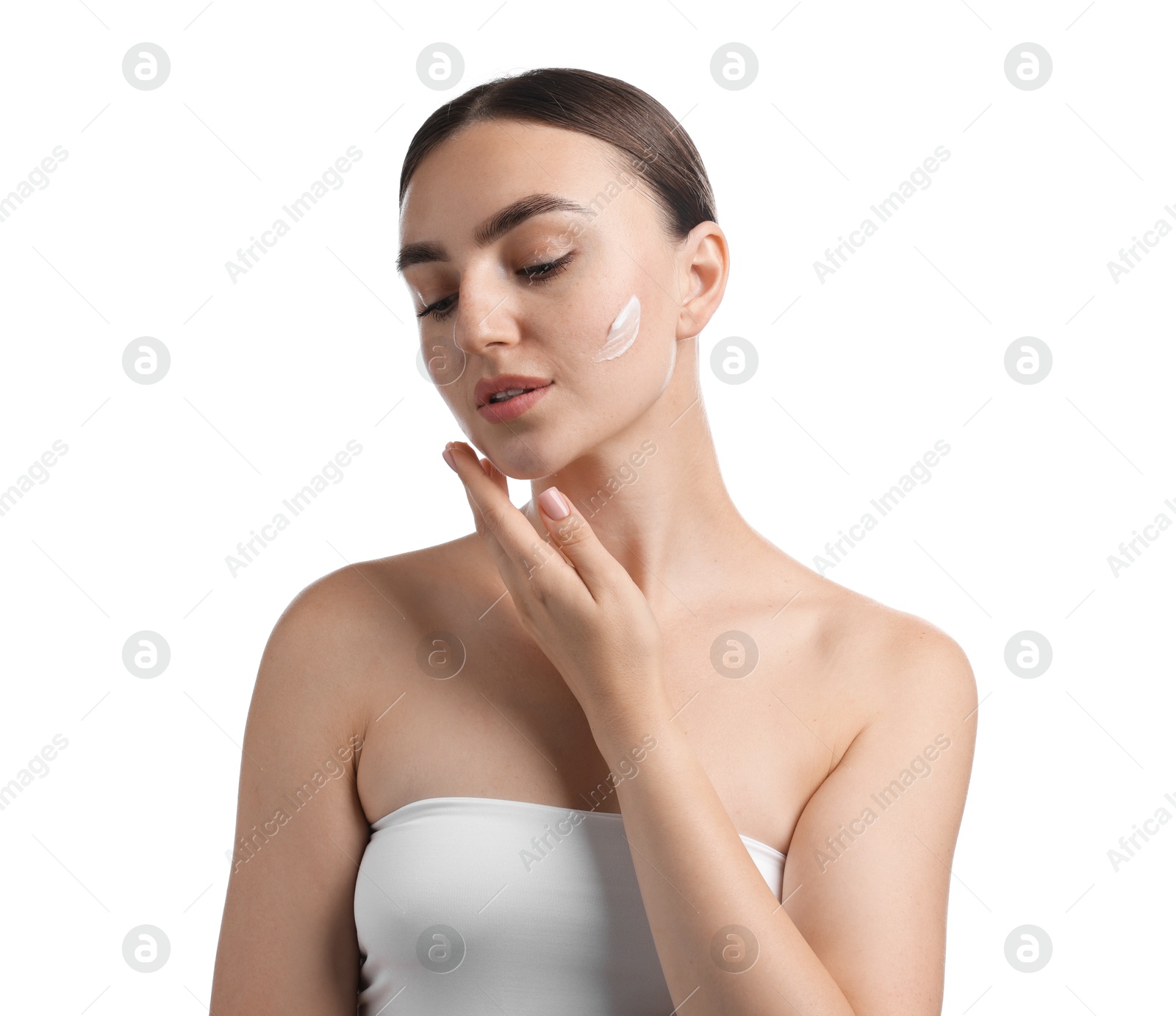 Beautiful woman applying cream onto her face on white background Photo of Beautiful woman applying cream onto her face on white background