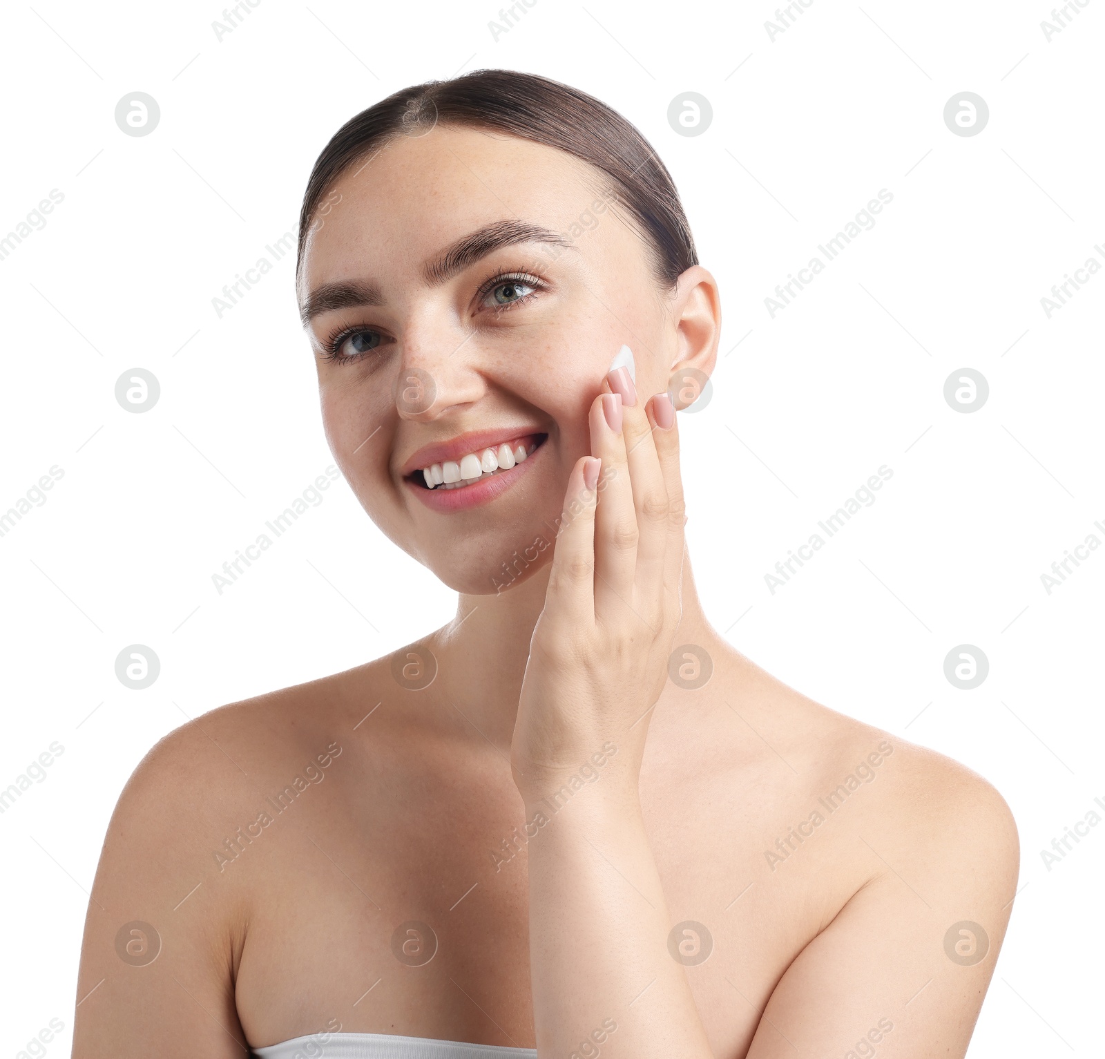 Photo of Beautiful woman applying cream onto her face on white background