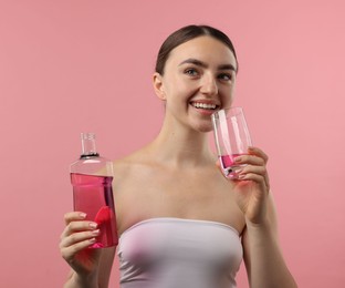 Photo of Woman rinsing mouth with mouthwash on pink background. Oral hygiene