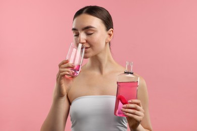 Photo of Woman rinsing mouth with mouthwash on pink background. Oral hygiene