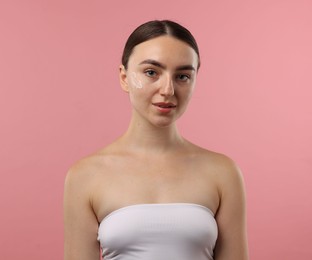 Photo of Beautiful woman with cream on her face against pink background