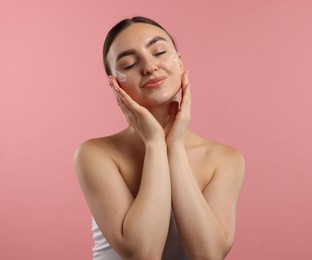 Photo of Beautiful woman with cream on her face against pink background