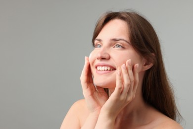 Photo of Beautiful woman with cream on her face against gray background. Space for text