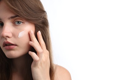Photo of Beautiful woman with cream on her face against white background, closeup. Space for text