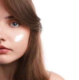 Photo of Beautiful woman with cream on her face against white background, closeup