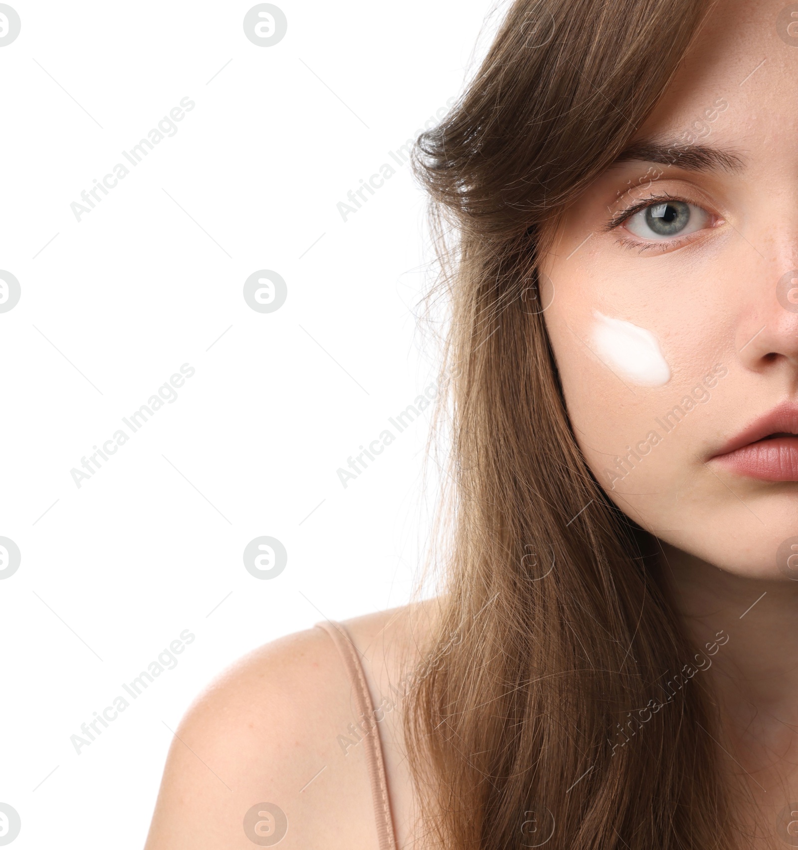 Photo of Beautiful woman with cream on her face against white background, closeup