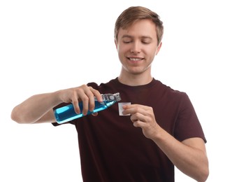 Photo of Man pouring mouthwash into cap on white background. Oral hygiene
