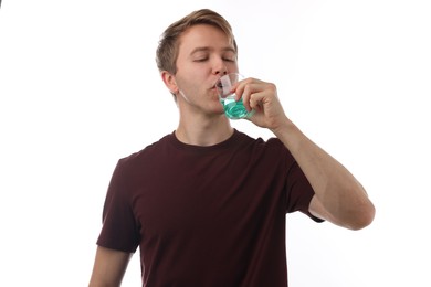 Photo of Man rinsing mouth with mouthwash on white background. Oral hygiene