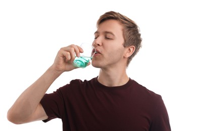 Photo of Man rinsing mouth with mouthwash on white background. Oral hygiene