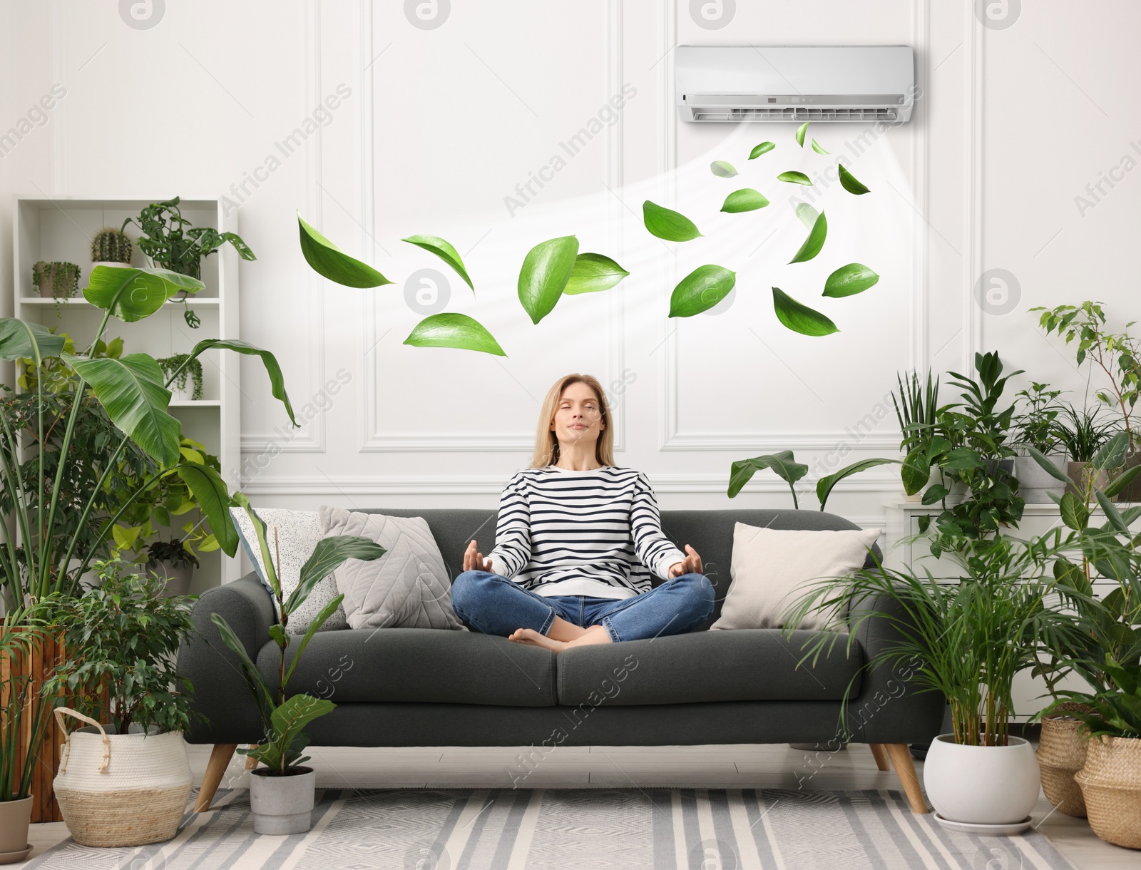 Image of Woman meditating on sofa surrounded by potted houseplants at home. Air conditioner keeping comfortable temperature in room
