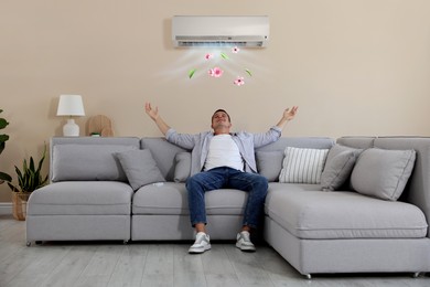 Image of Man enjoying comfortable temperature on sofa in room with air conditioner