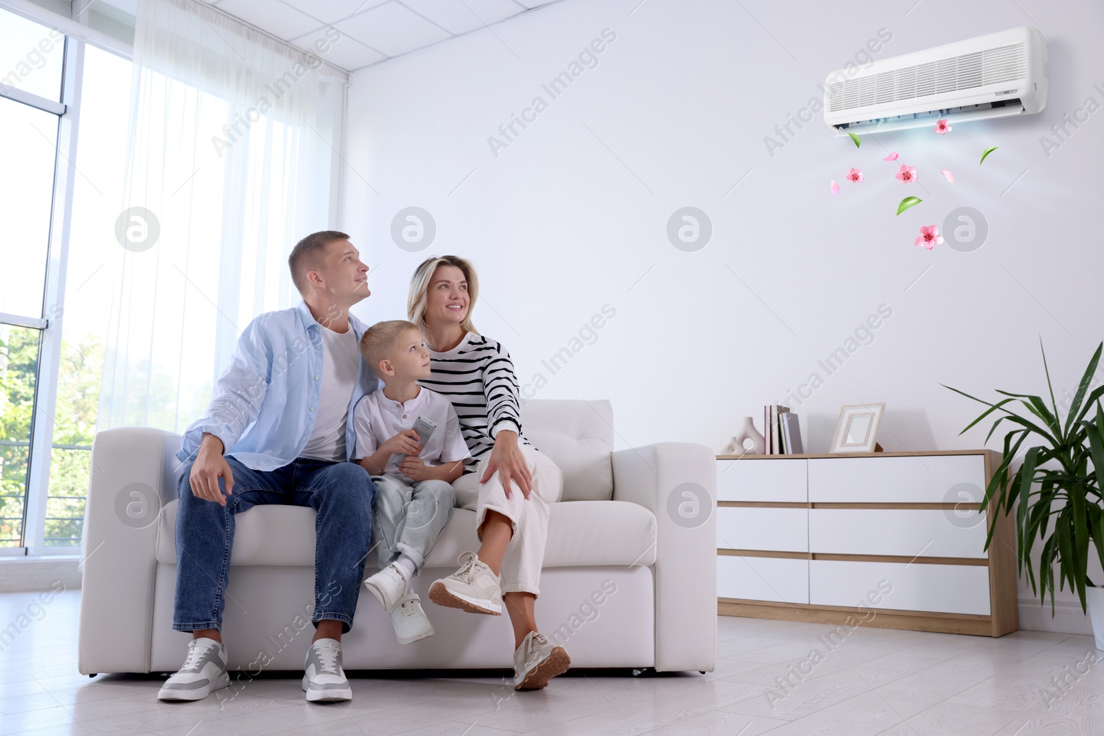 Little boy using remote to control air conditioner and his parents at home Image of Little boy using remote to control air conditioner and his parents at home