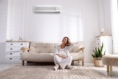 Image of Woman enjoying comfortable temperature in room with air conditioner