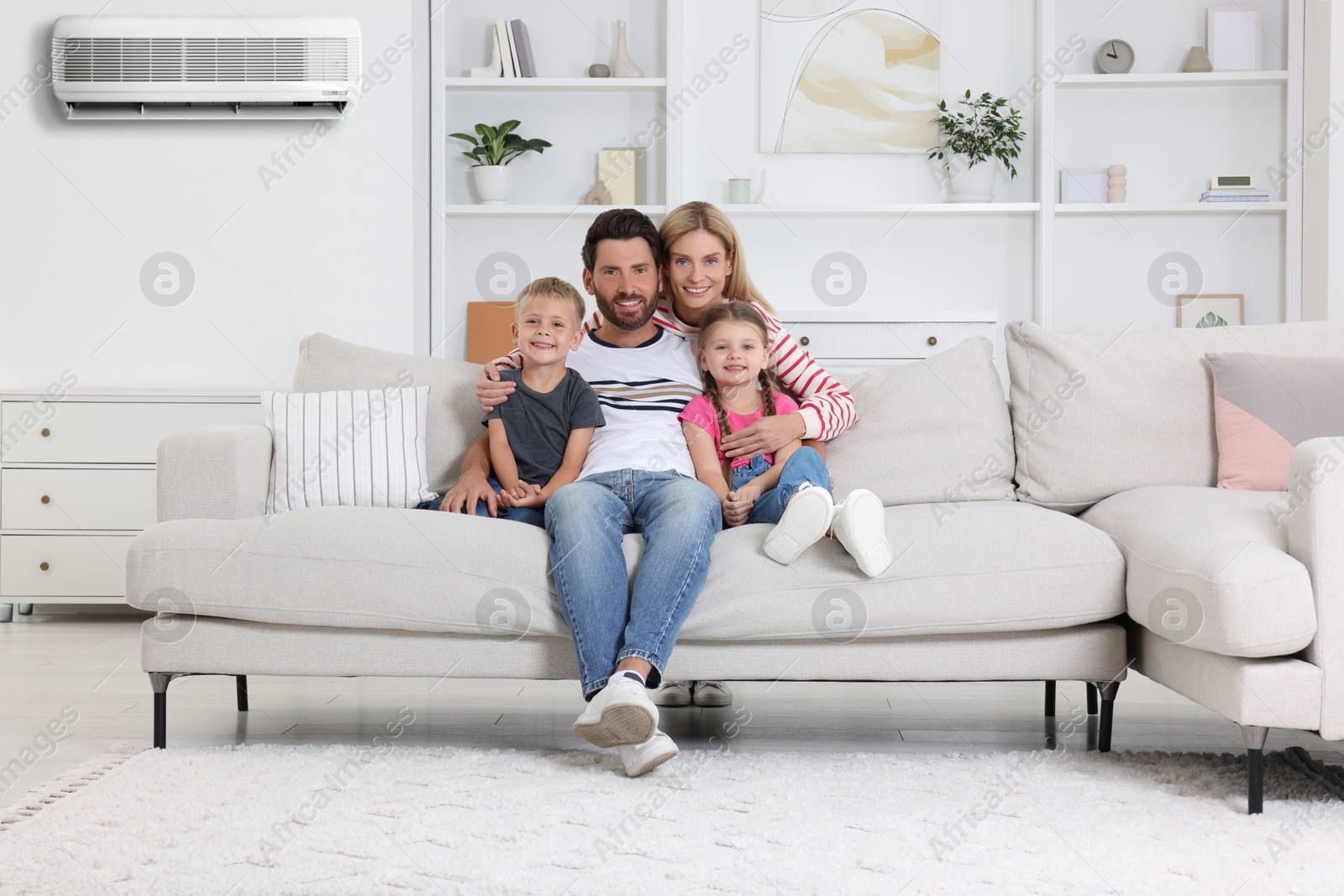Image of Happy family with children at home. Air conditioner keeping comfortable temperature in room