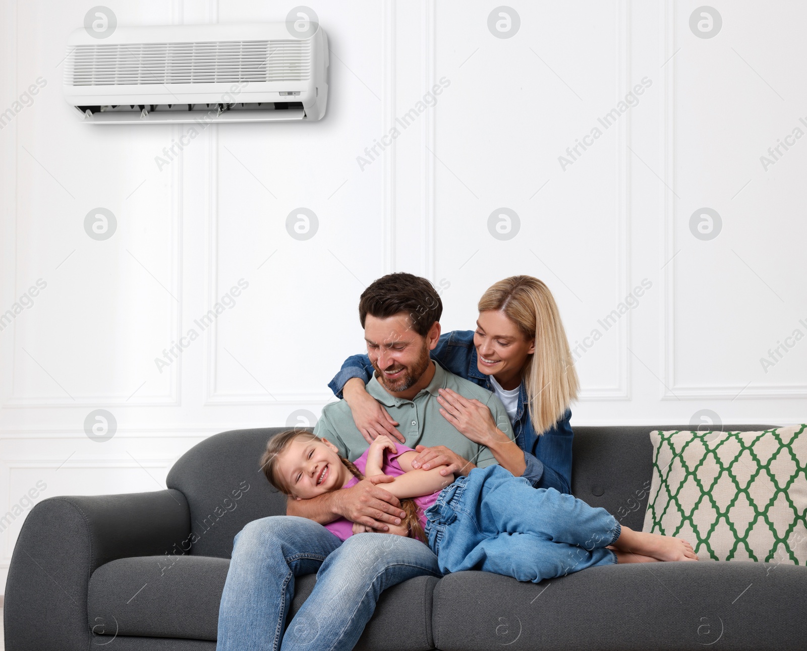 Image of Happy family having fun together at home. Air conditioner keeping comfortable temperature in room
