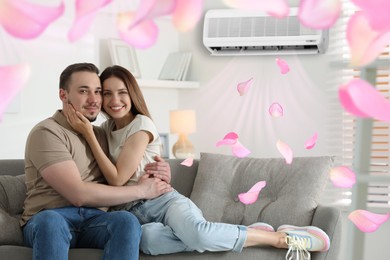 Image of Happy couple on sofa at home. Air conditioner keeping comfortable temperature in room