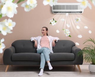 Image of Smiling woman relaxing on sofa at home. Air conditioner keeping comfortable temperature in room