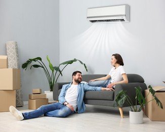 Image of Happy couple resting at home. Air conditioner keeping comfortable temperature in room