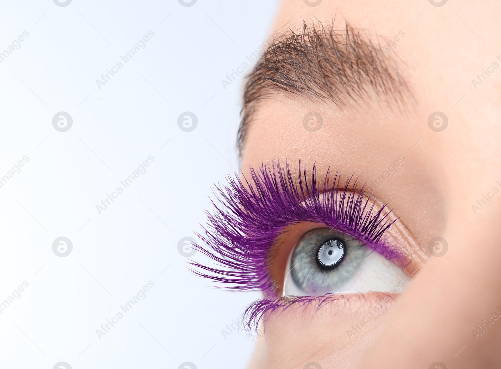 Image of Young woman with beautiful purple eyelashes on light background, closeup