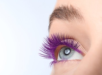 Image of Young woman with beautiful purple eyelashes on light background, closeup