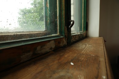 Photo of Old window with wooden sill in room, closeup